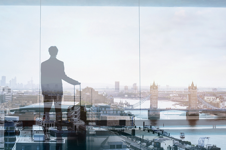 a successful MBA graduate looking out of his large office window