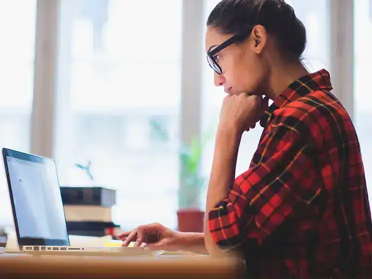 female college student preparing for the GRE on her laptop