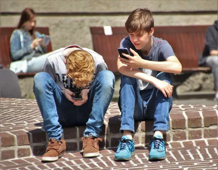 Two teenage boys preventing cyberbullying on their phones