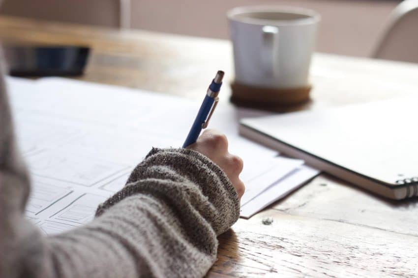 Person writing with a pen on a paper