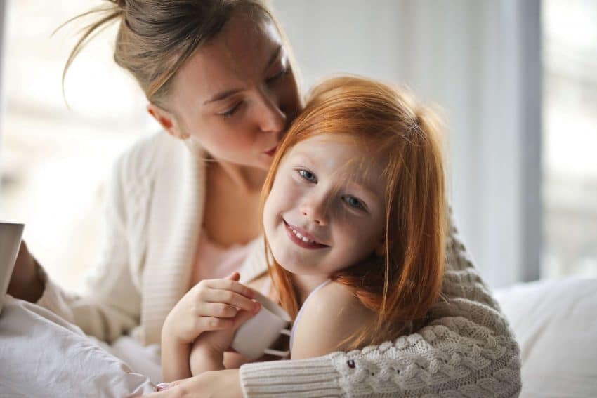 Mother embracing daughter at home