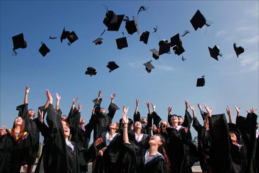 Students throwing graduation caps in the air