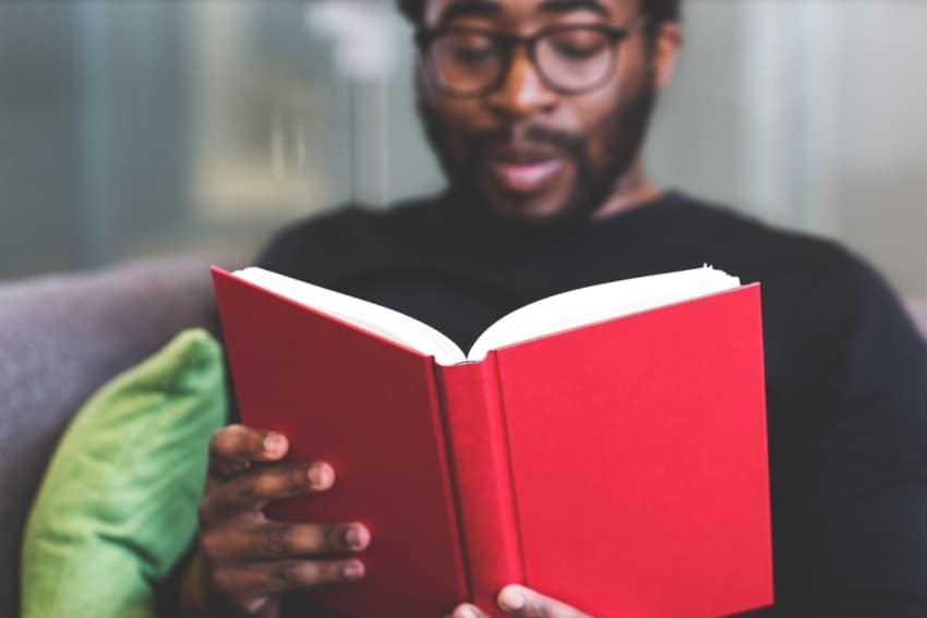 Adult student at the University of the People reading a book