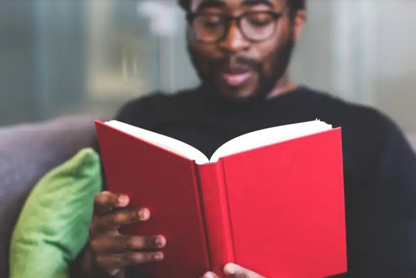 Adult student at the University of the People reading a book