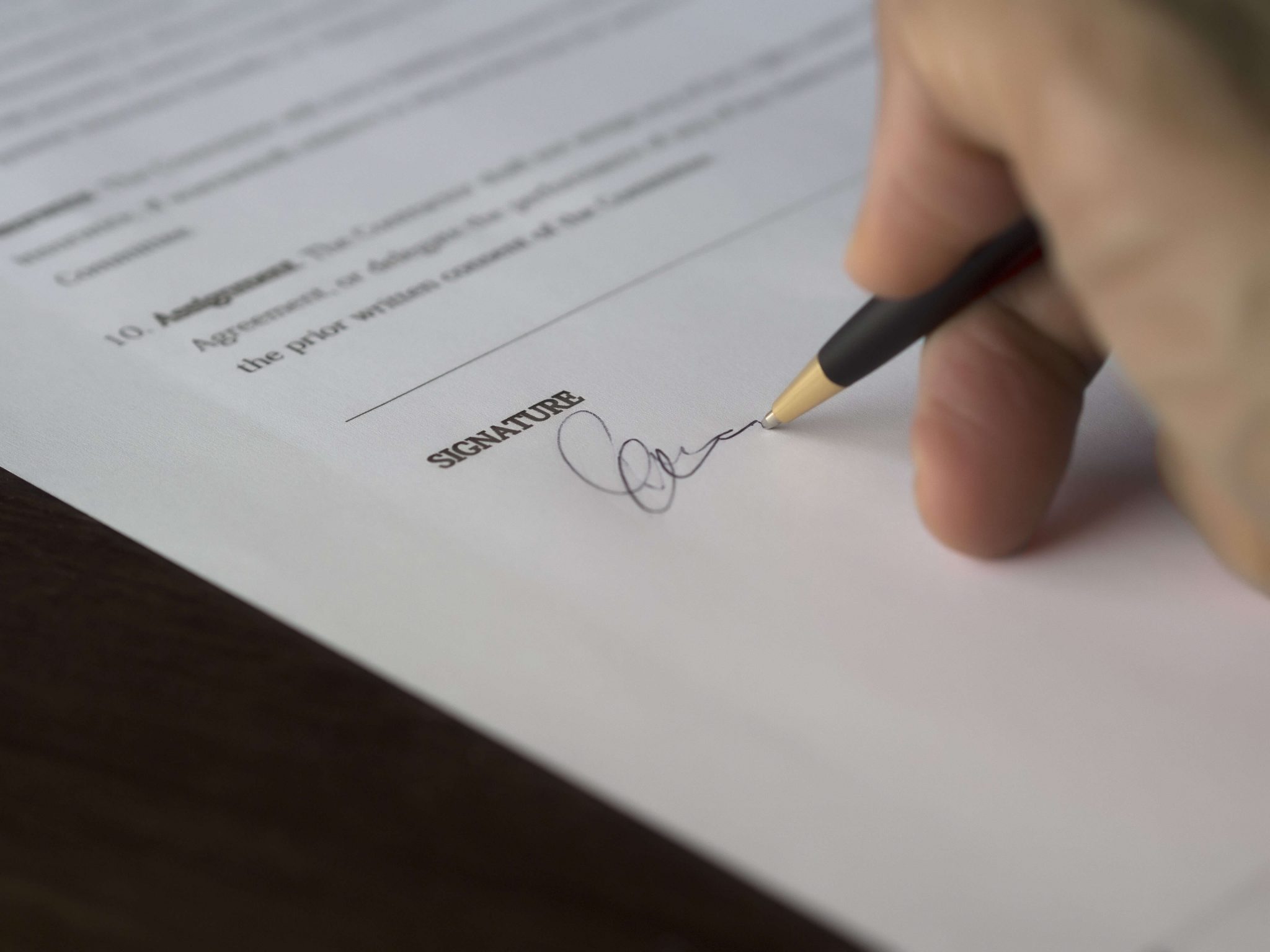 Signing a written contract with pen