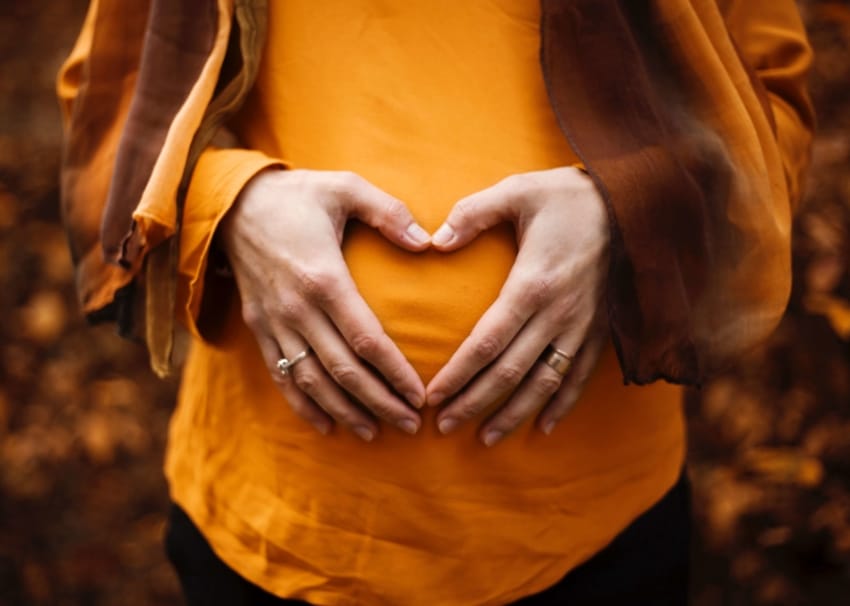 Pregnant student holding stomach