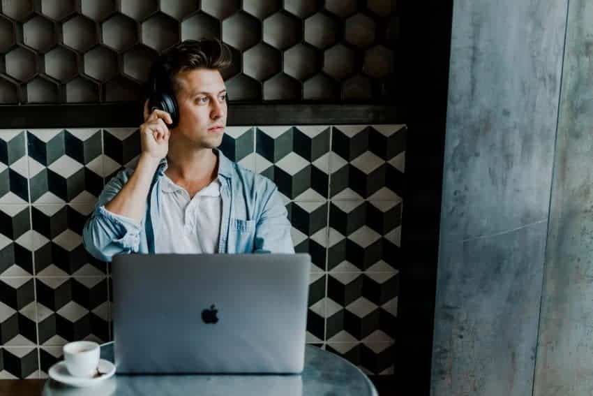 Person sitting with a laptop and headphones