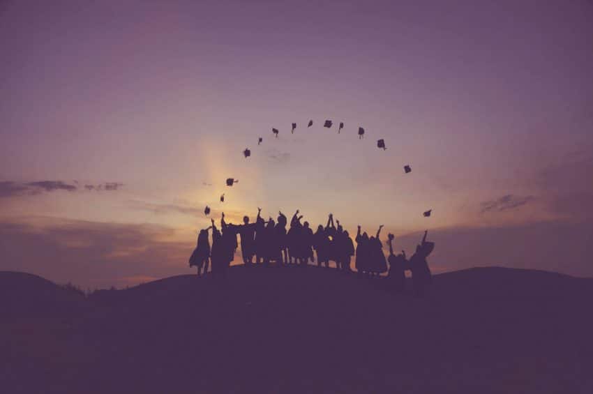 Silhouettes of graduates throwing their caps in the air