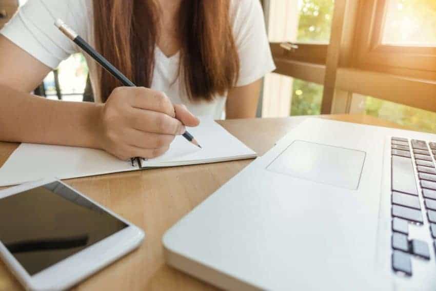 Girl studying for SAT with laptop and notepad