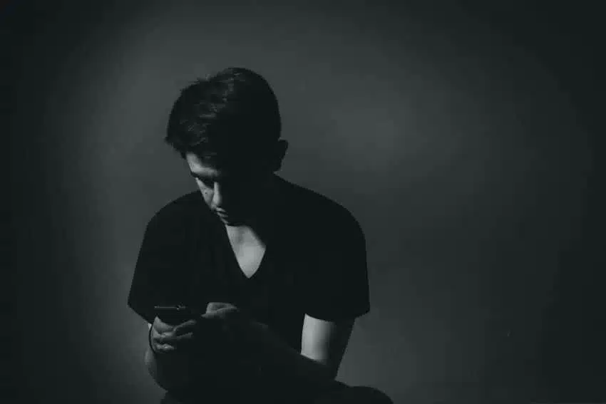 Teenage boy experiencing cyberbullying on his phone