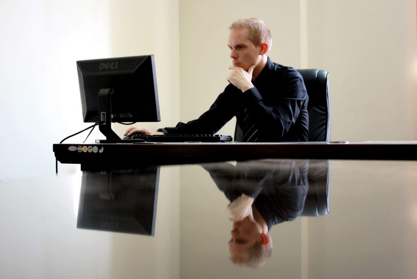 A man using his reflective thinking skills while sitting in front of his computer.