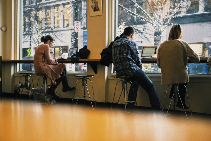 “Three University of the People students studying at a cafe”