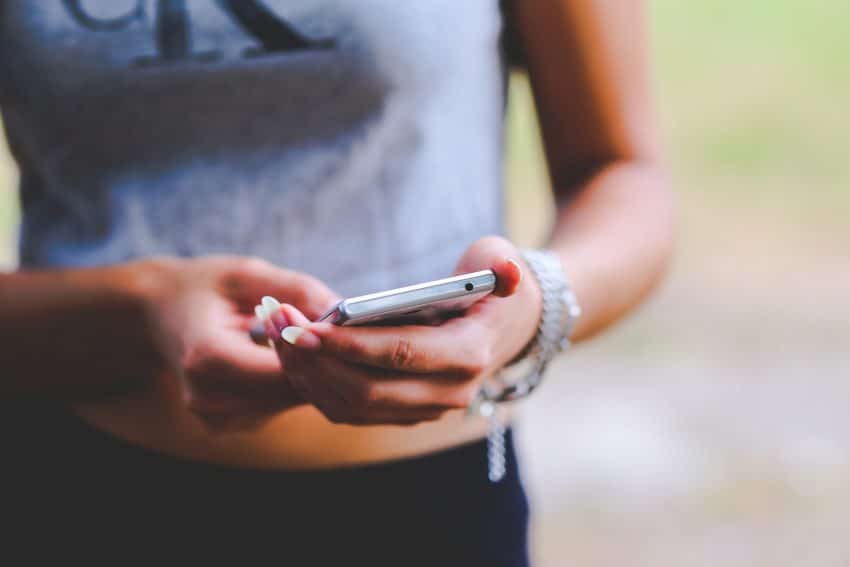 University of the People student holding phone