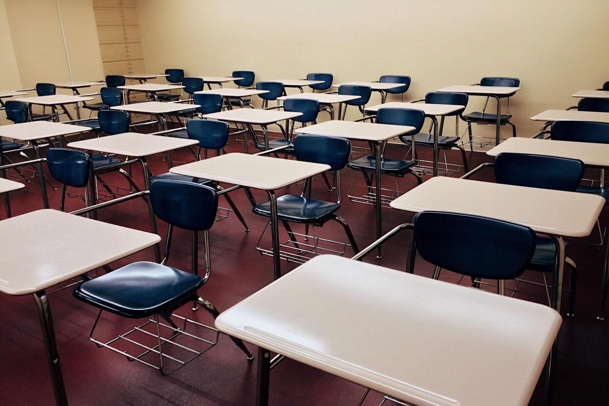 “Empty college classroom chairs and desks”