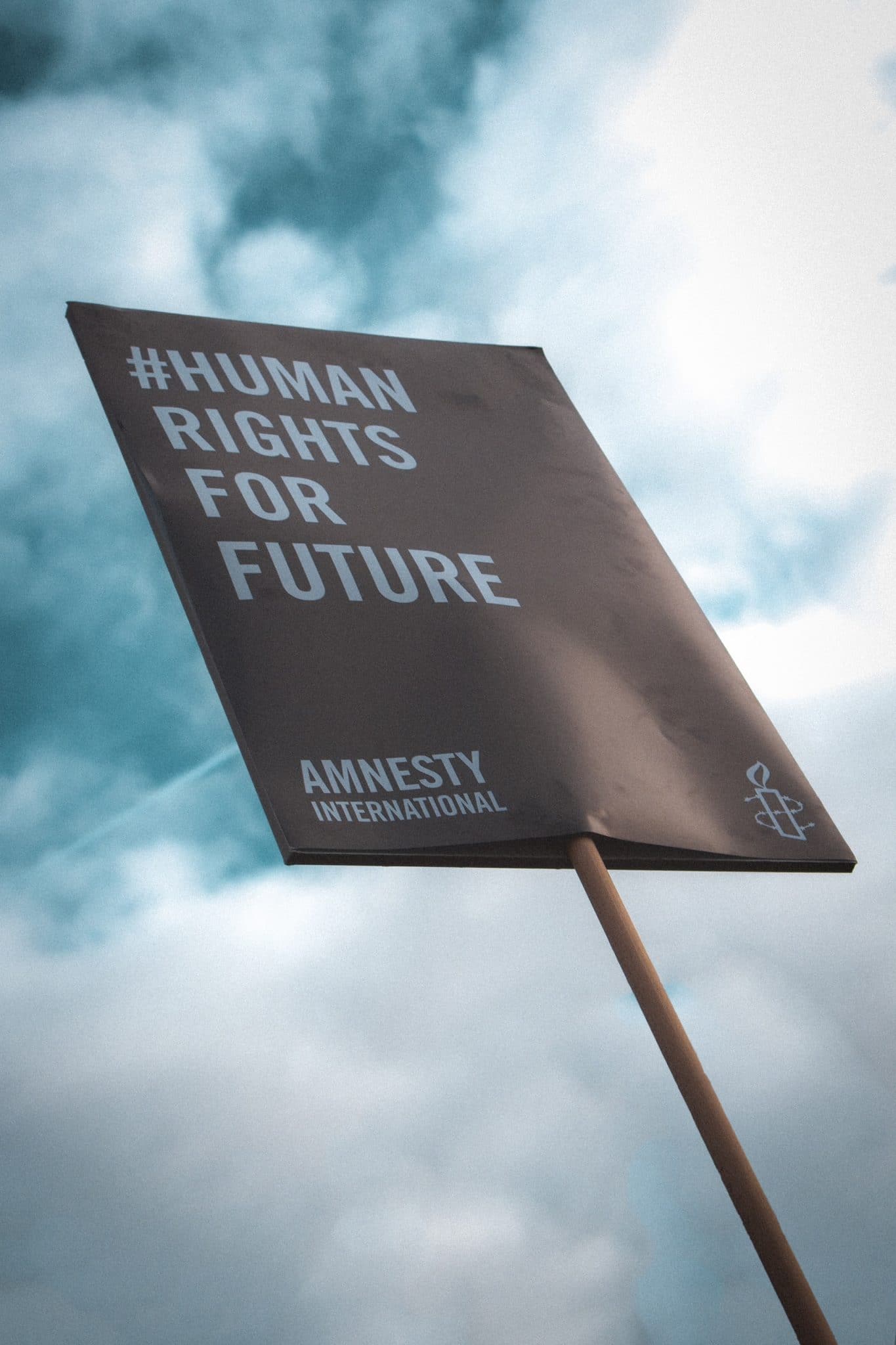 NGO Amnesty International poster against cloudy sky