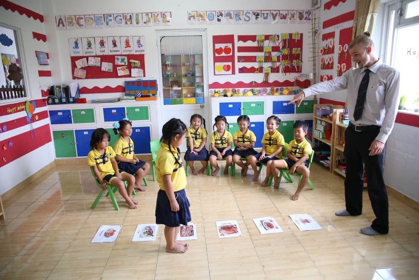TEFL teacher playing a game with students in a classroom