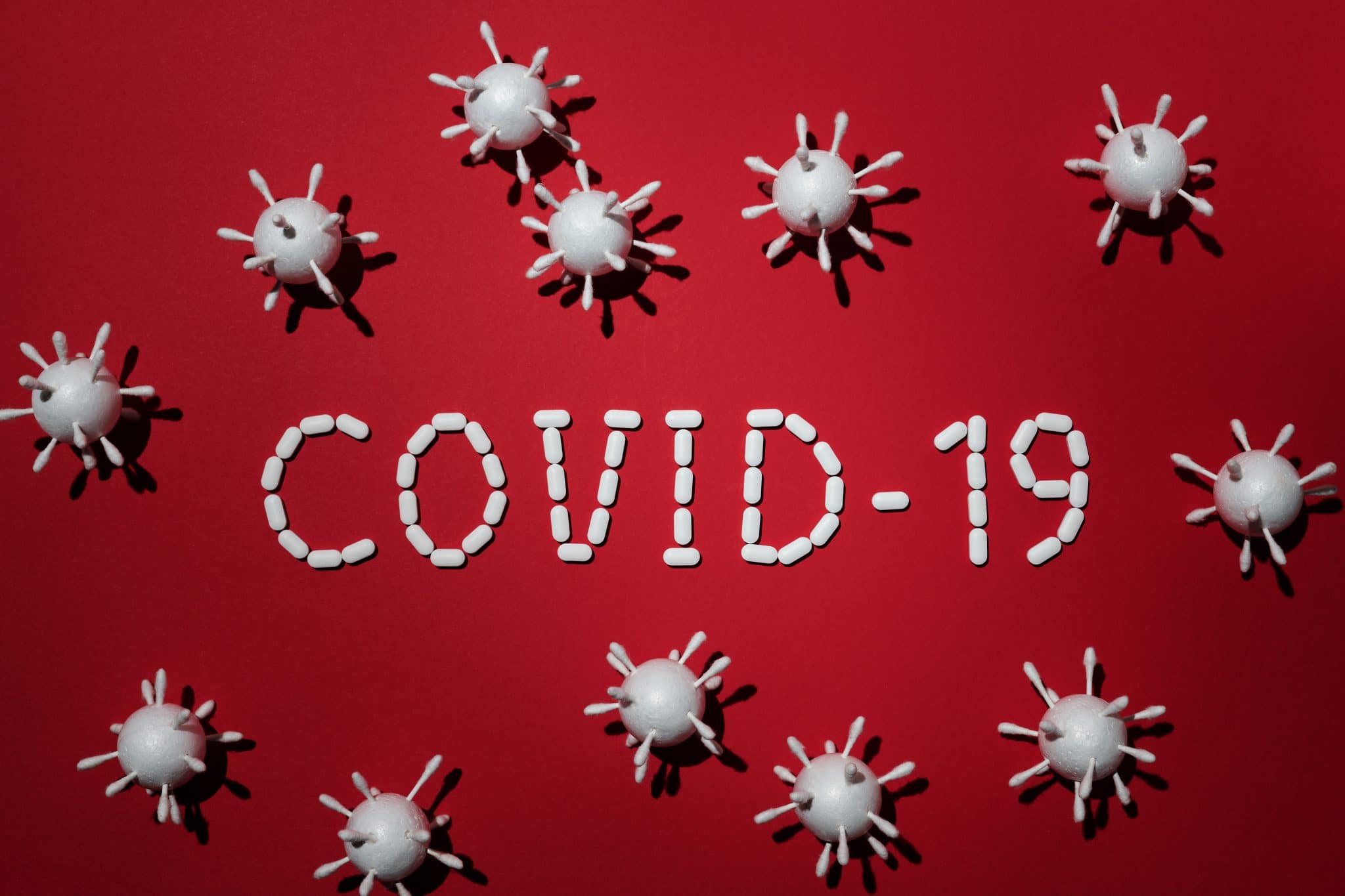 COVID-10 spelled in white pills against red background