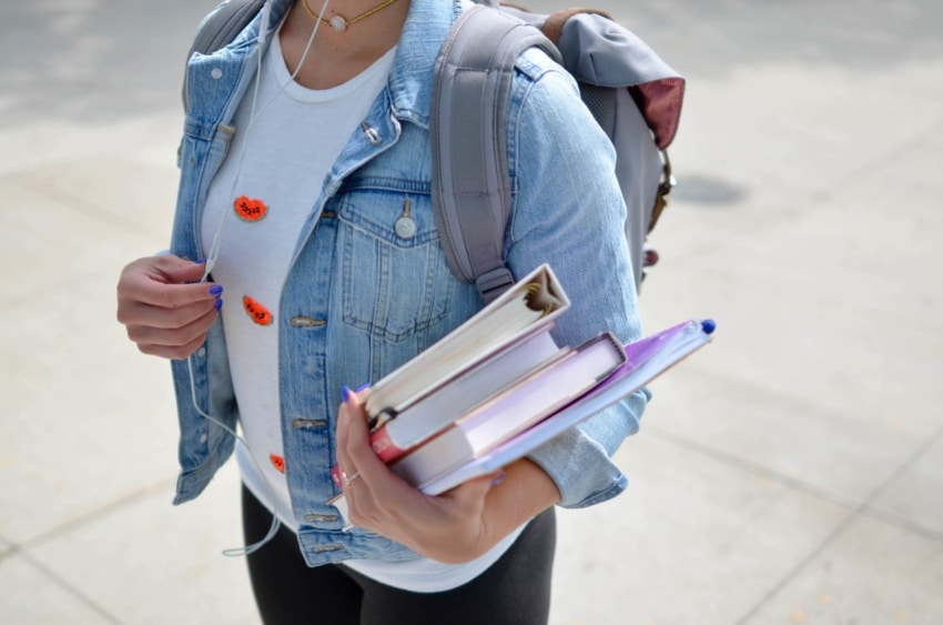 University of the People student with backpack holding study materials