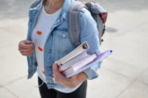 University of the People student carrying general education course books