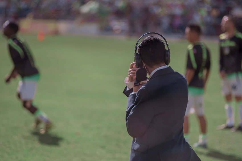 Sports reporter with a microphone on the sidelines of a game