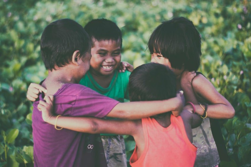 Four children huddled in a circle