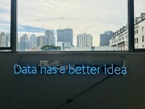 Neon sign of “data has a better idea” with a cityscape