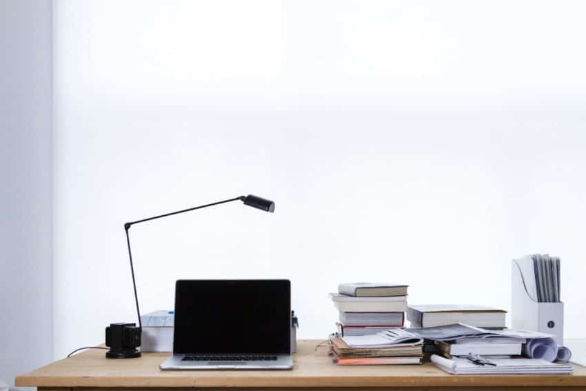 Student’s workspace for writing a dissertation with laptop and research books