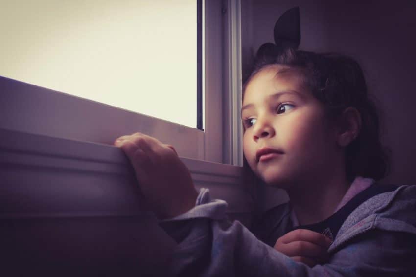 Anxious young girl staring out the window