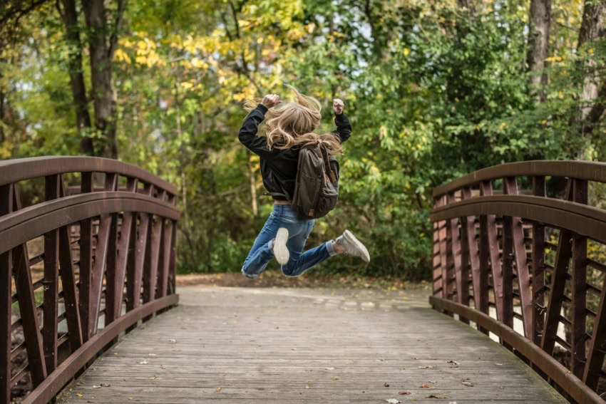 A female student jumping for joy from success in school