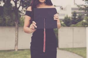 woman holding up a graduation cap