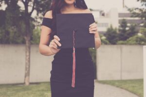 Woman graduating with an MBA, holding her cap.