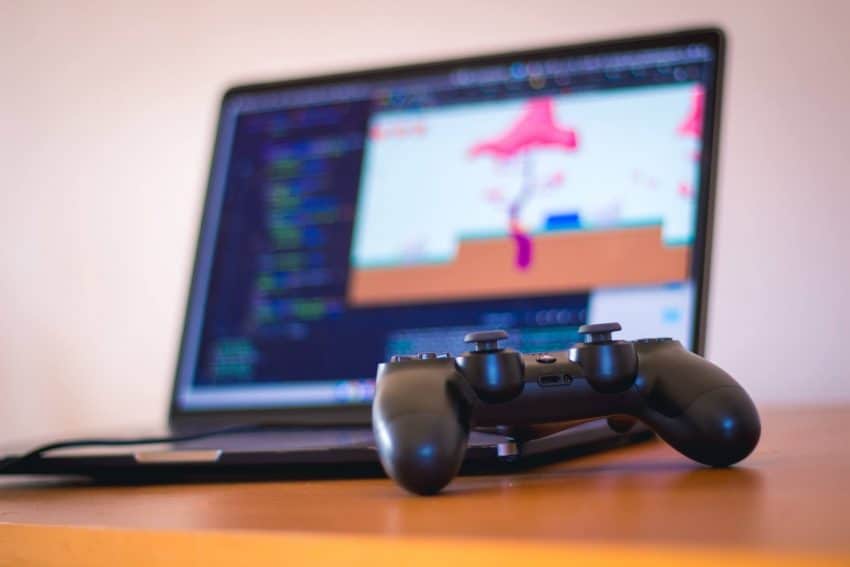 Video game controller in front of a black laptop