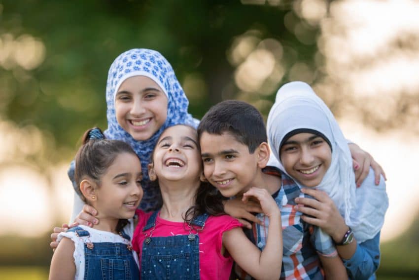 Muslim refugee siblings smiling happy
