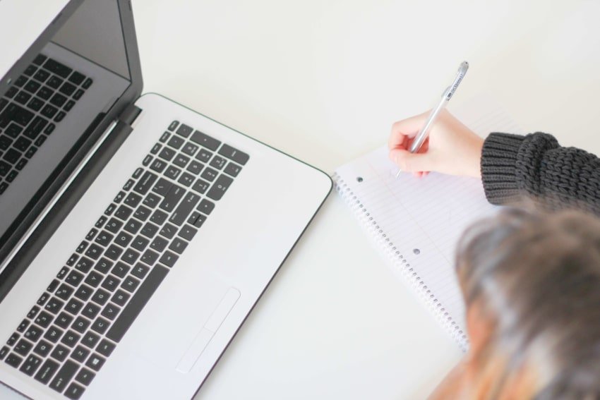 Student with notebook and laptop for online school