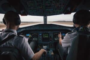 Pilots in the cockpit flying a plane. 