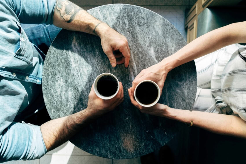 Coach vs mentor sit together with coffee