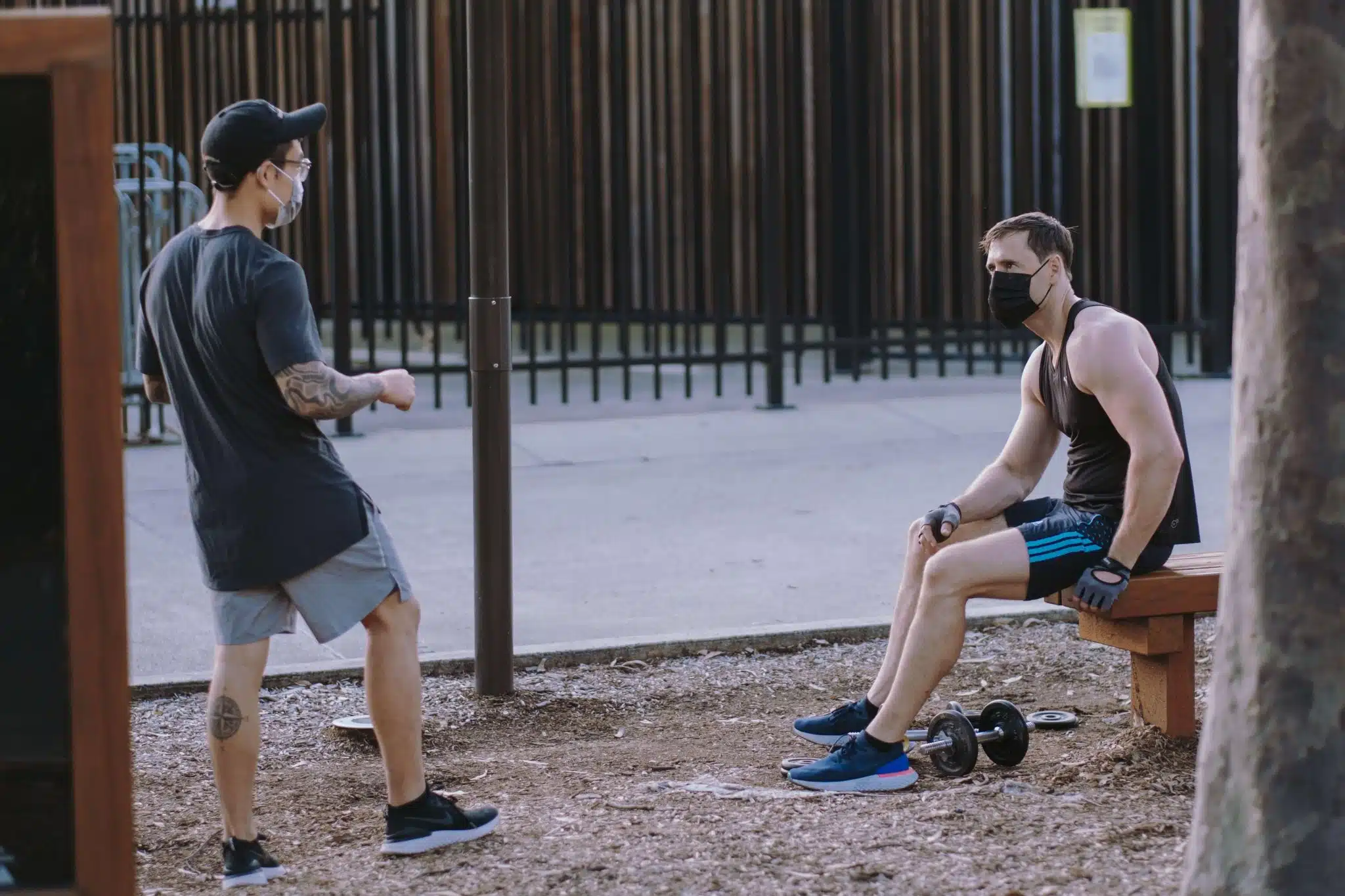 Friends talking to one another with masks and from a distance