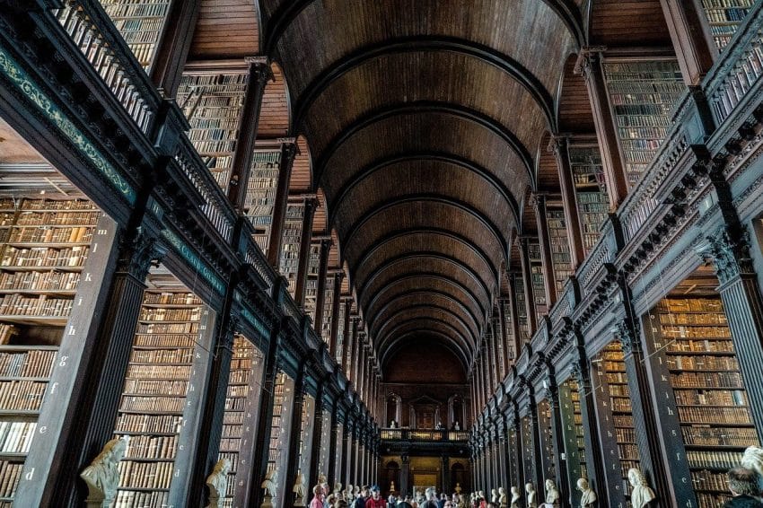 Shelves upon shelves in a college library with an arched ceiling