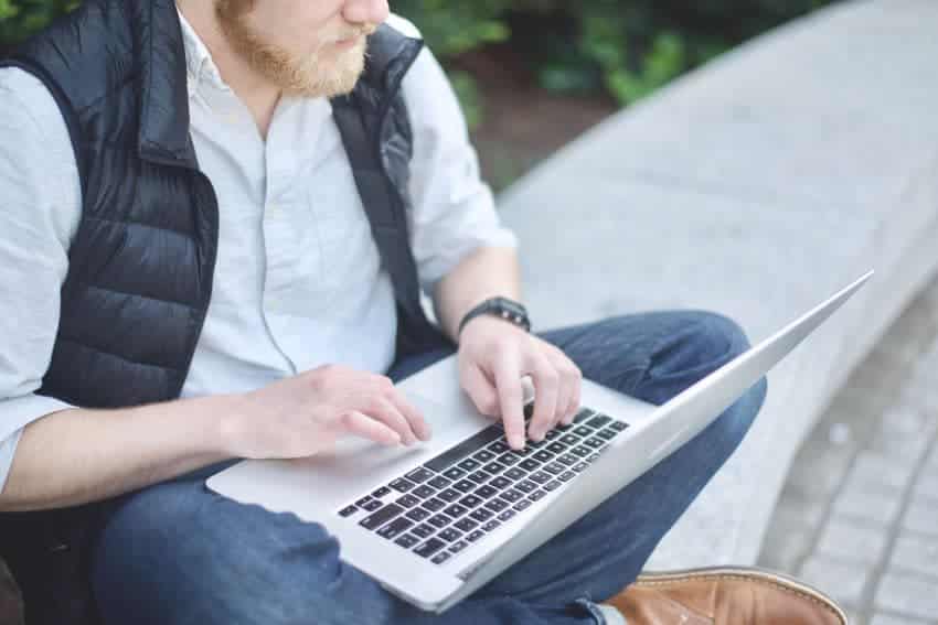 Man sitting with macbook and smiling