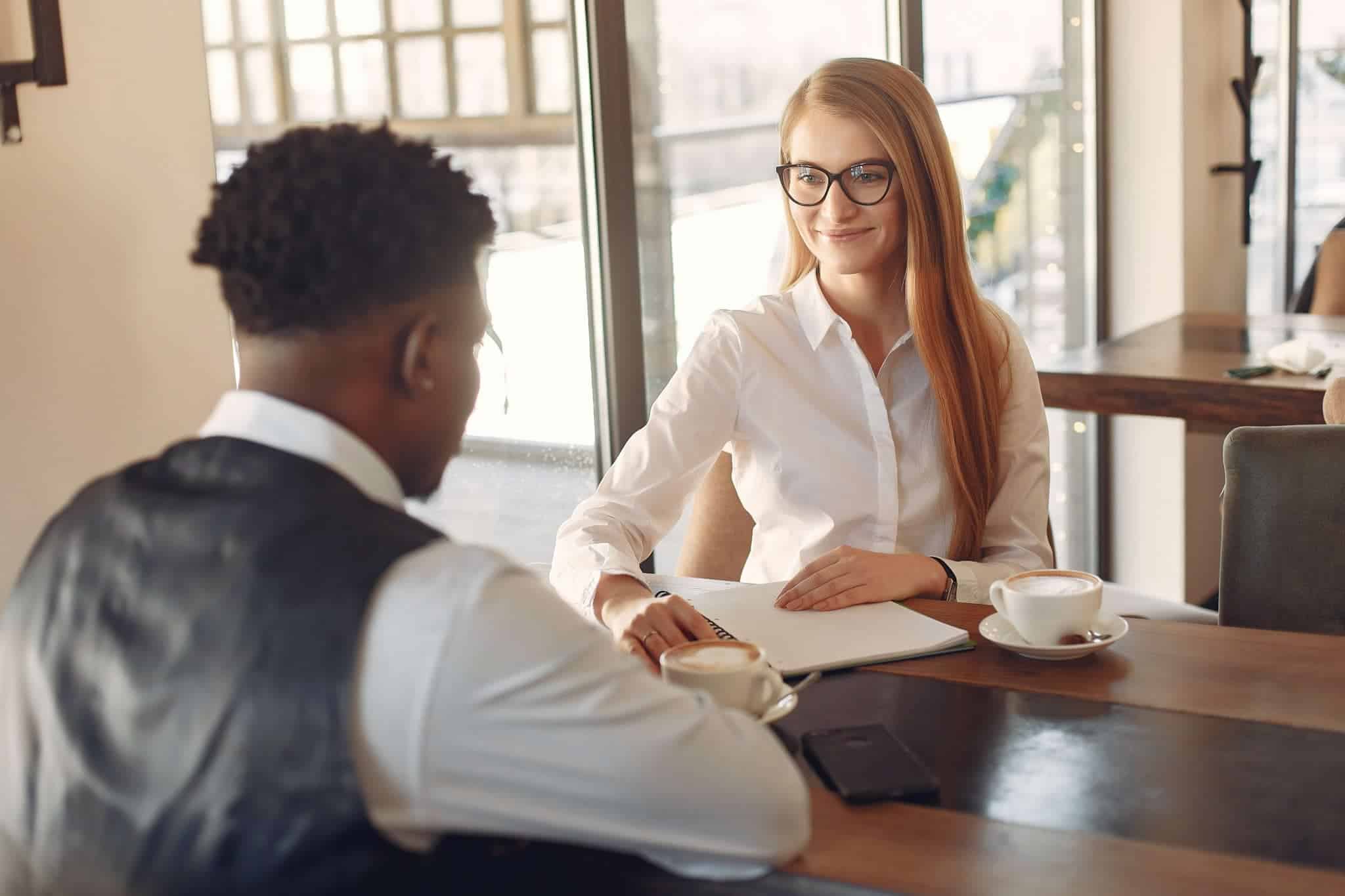 An interviewer conducting an interview over coffee with a potential candidate to teach at her school