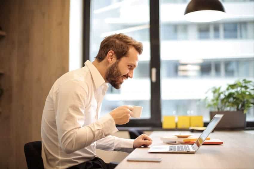 A happy introverted man working in front of his laptop at the office