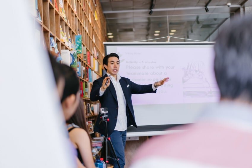 “Public speaker in front of projection at a library”