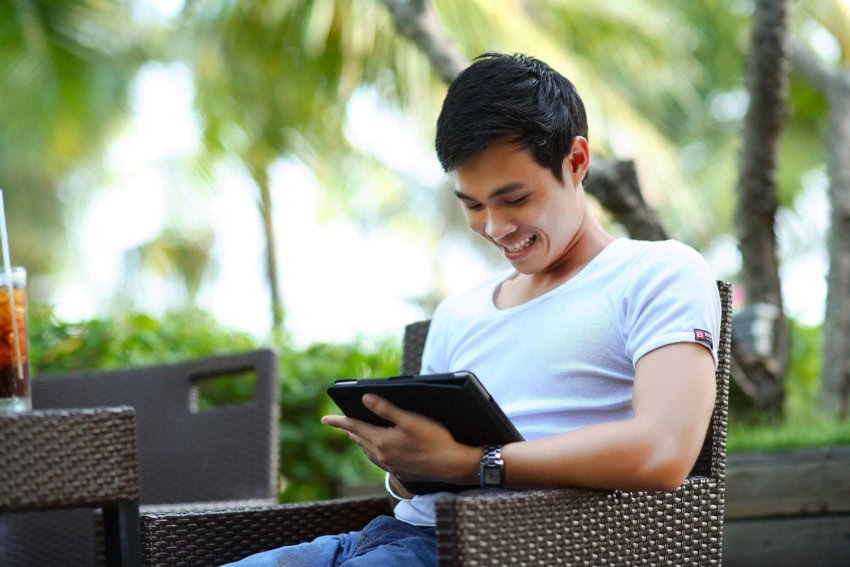 This man is volunteering from his tablet while on vacation on a tropical island.