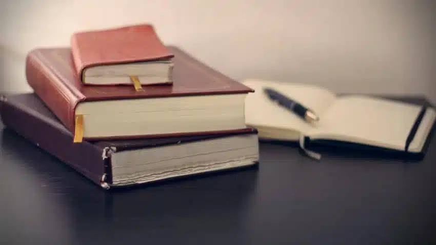 Stack of leatherbound books and an open journal