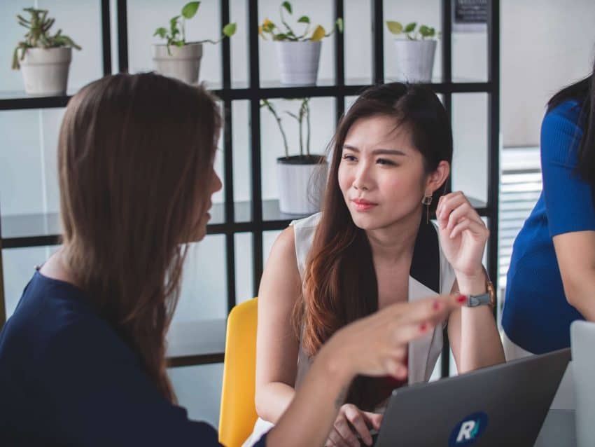 Girl actively listening to another girl in workplace