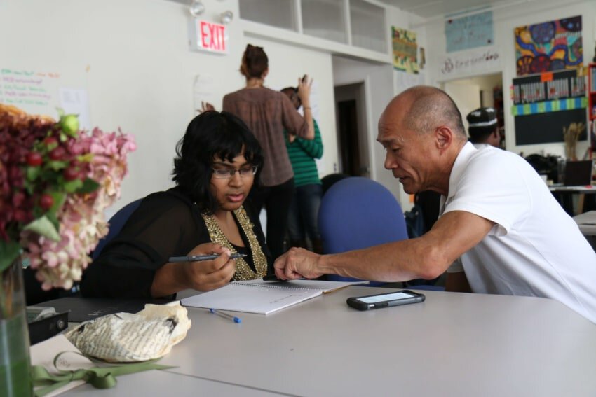 Mentor and mentee at coaching session with notebook