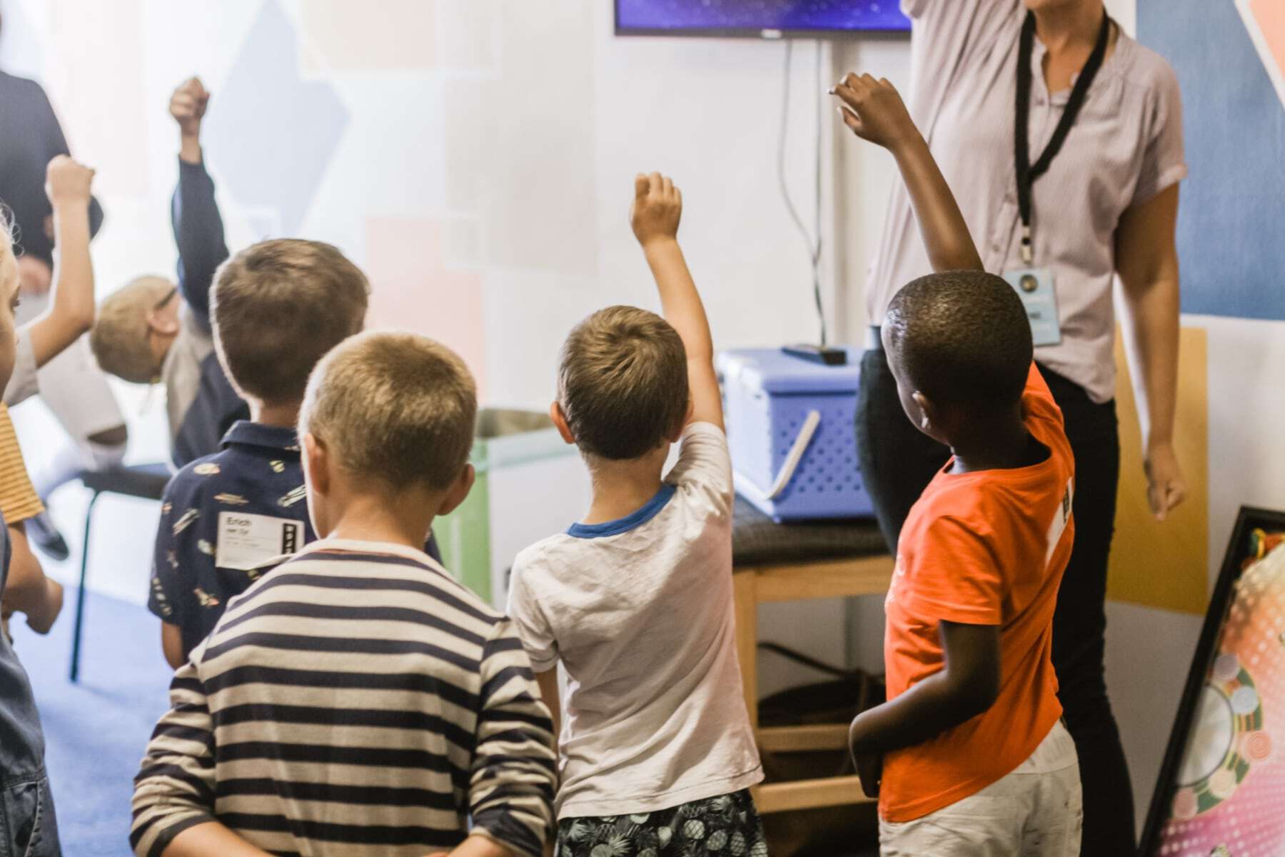 Teacher in front of students raising hands