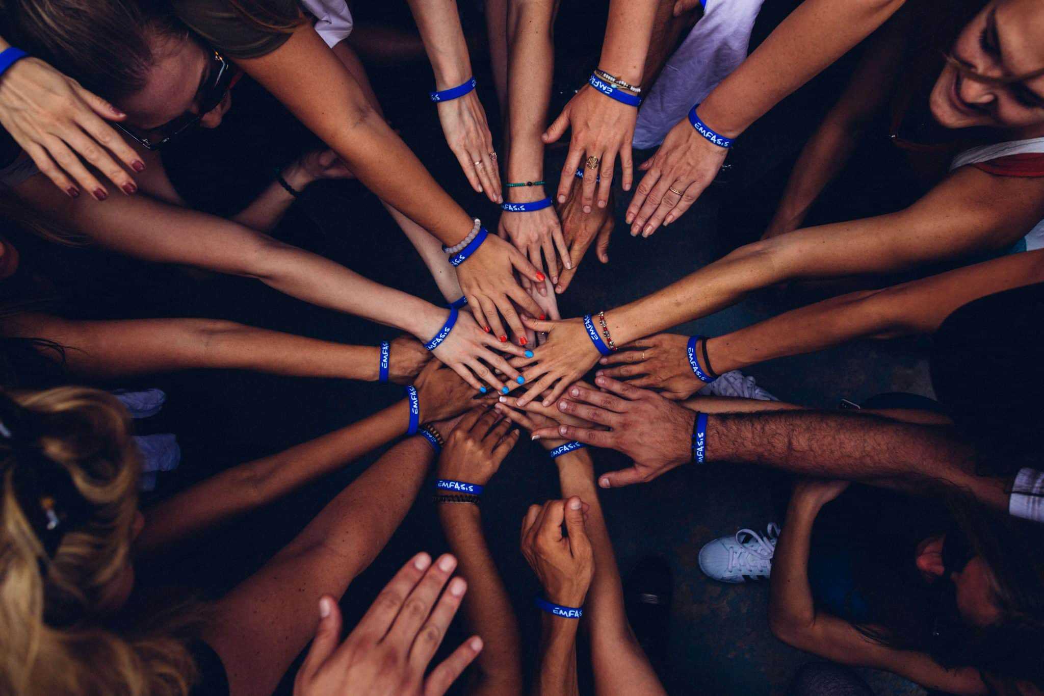 Teamwork and collaboration at University of the People with hands in a huddle