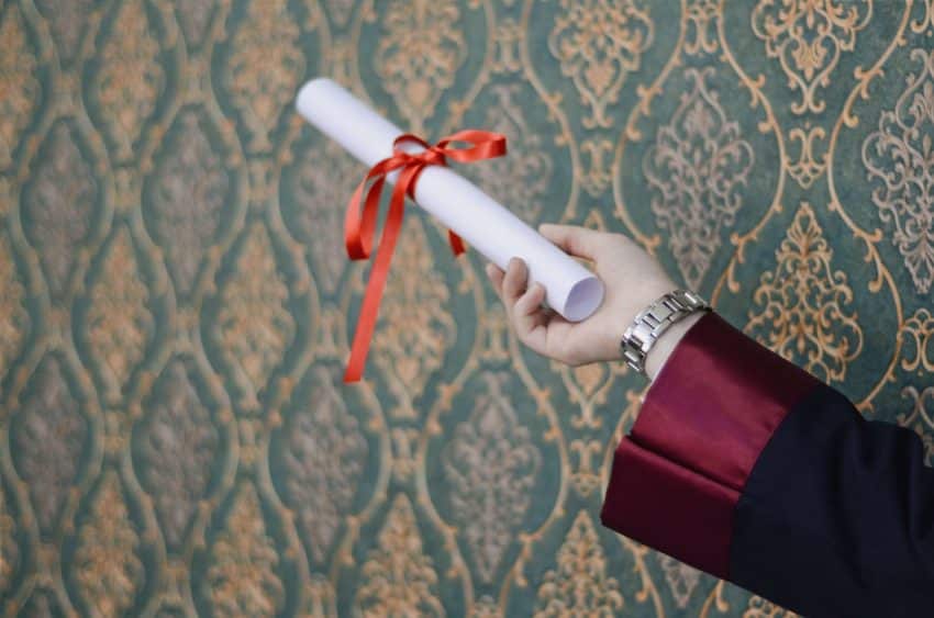 Woman holding a UoPeople diploma