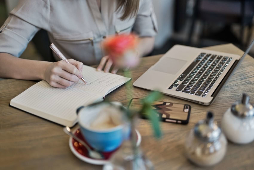 A student taking notes from an online lecture at the University Of The People